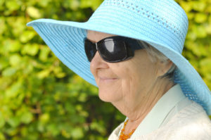older adult woman wearing sunglasses and summer hat