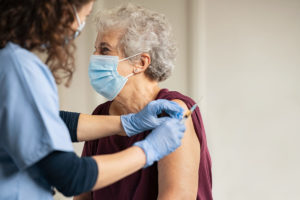 nurse giving older woman a covid vaccination