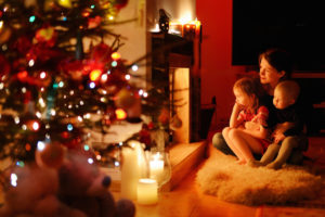 Woman sitting with children in front of Christmas tree_Acknowledging Grief During the Holidays