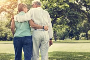 Senior Couple walking arm in arm from behind_Caring for a Loved One with Alzheimer's