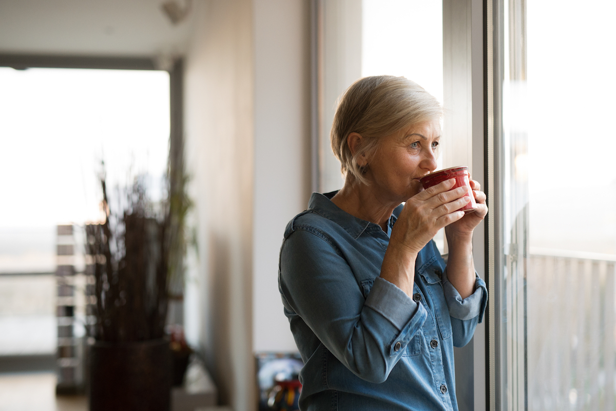Senior Woman Drinking Coffee and Looking Out Window_Franklin Park® Senior Living