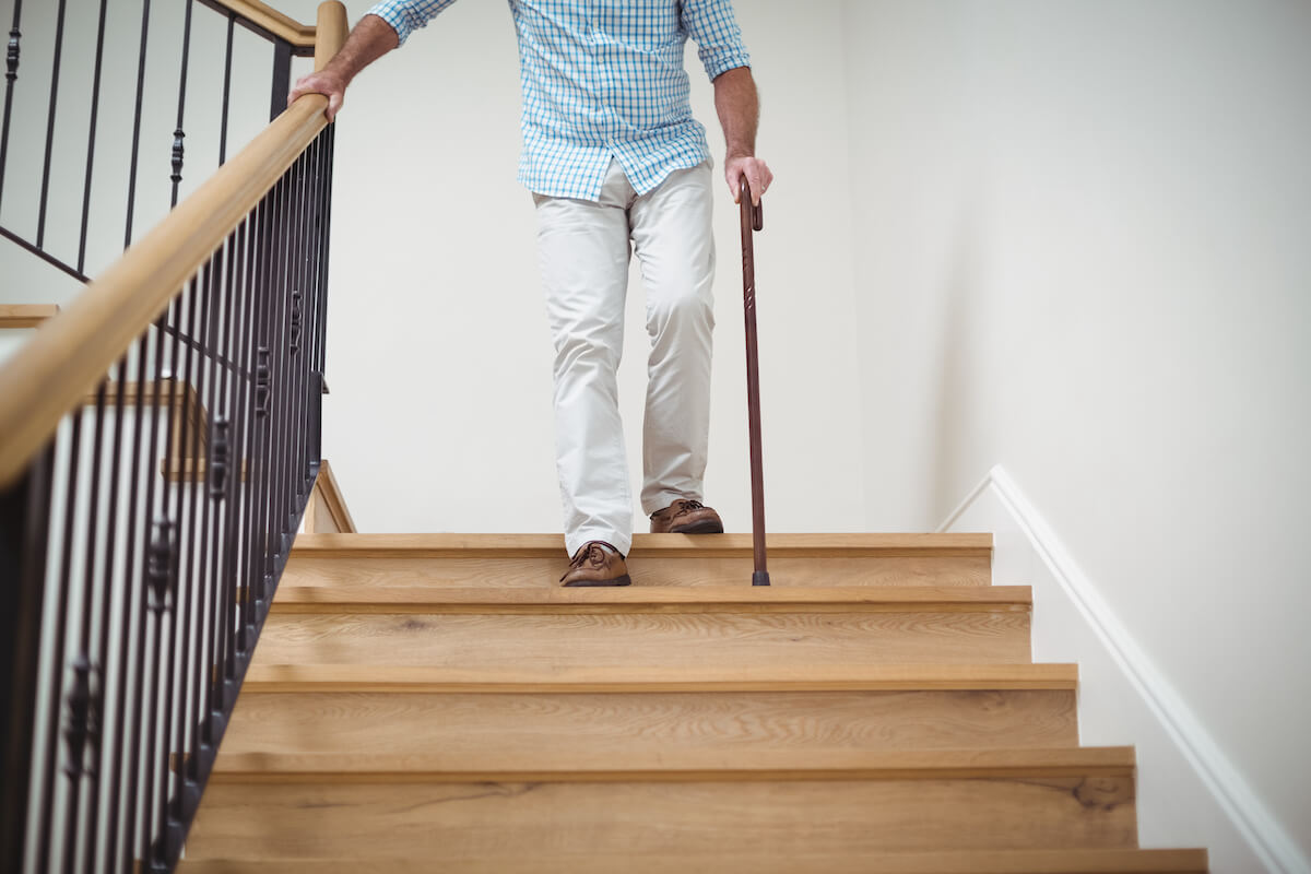 Older adults walking down stairs with cane_preventing falls