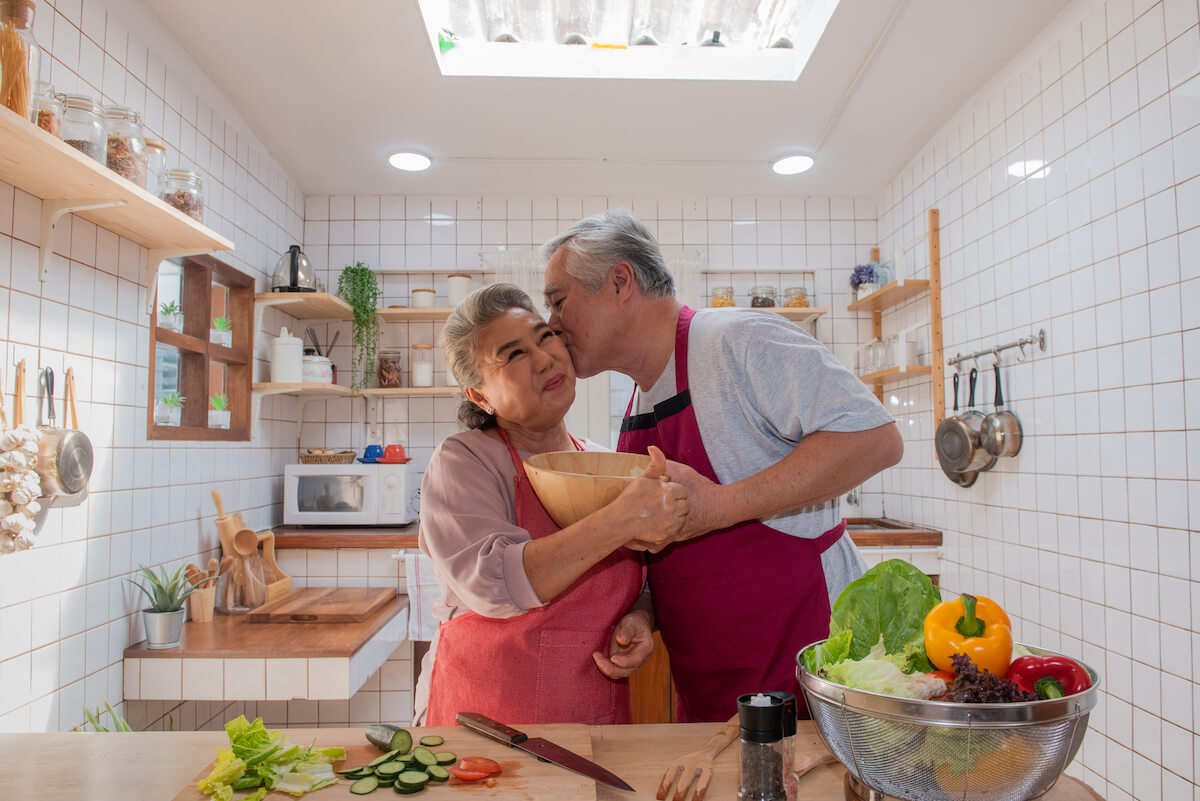 Senior man and woman cooking healthy food at home