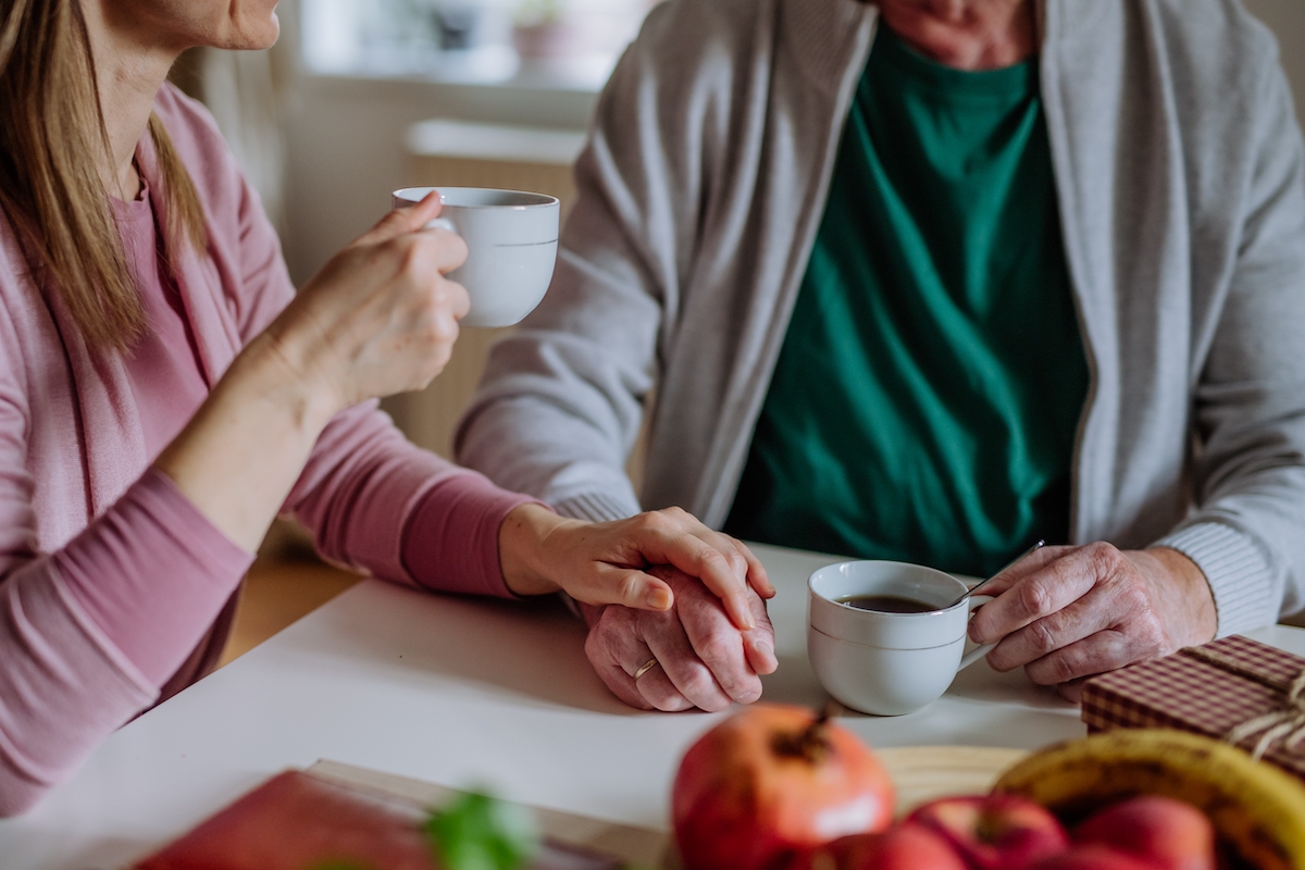 Senior Man and Adult Daughter Drinking Coffee Together at Home_Franklin Park® Senior Living