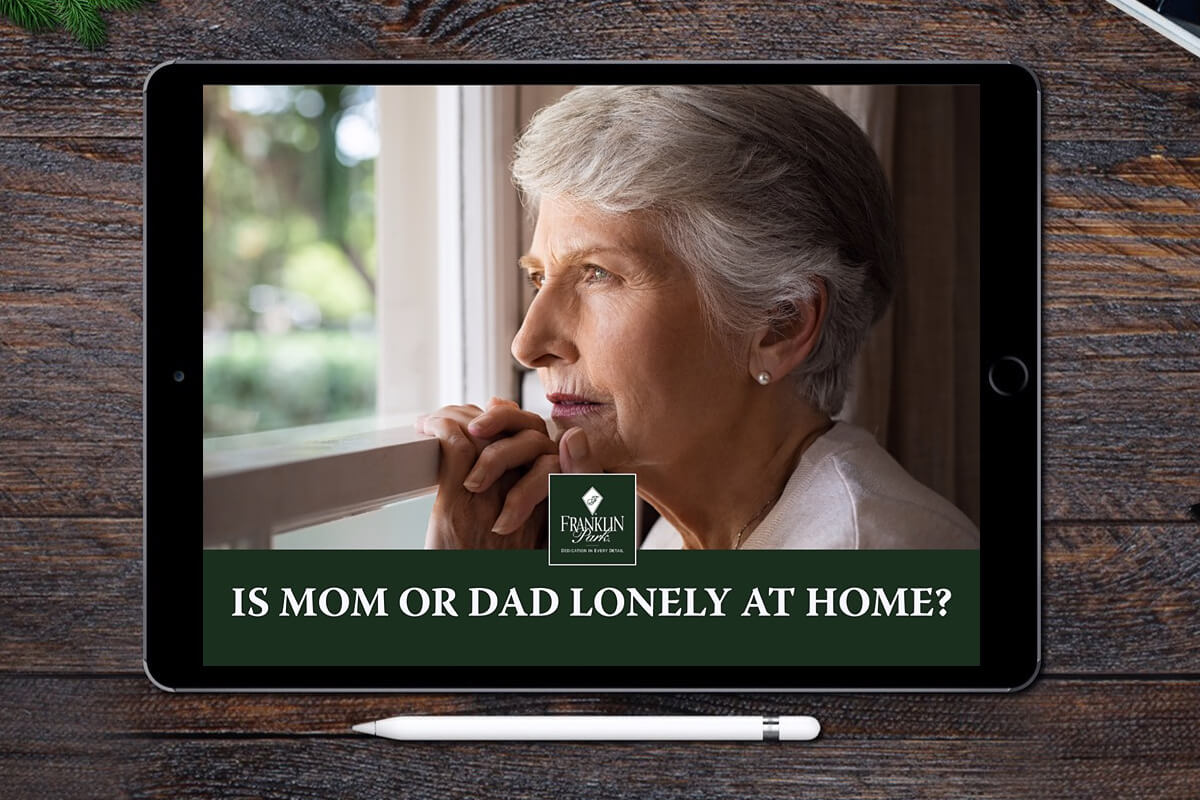 Senior woman looking out window on tablet screen