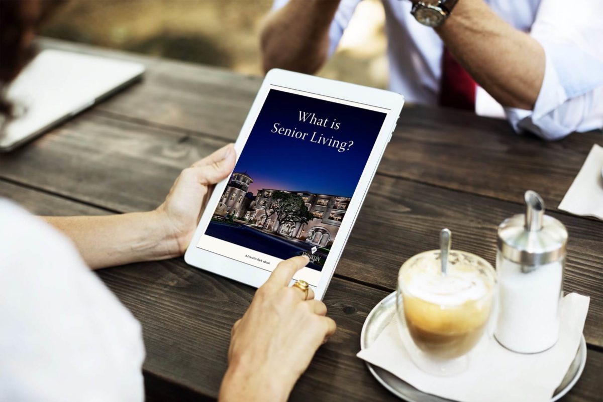 Person viewing senior living information on tablet