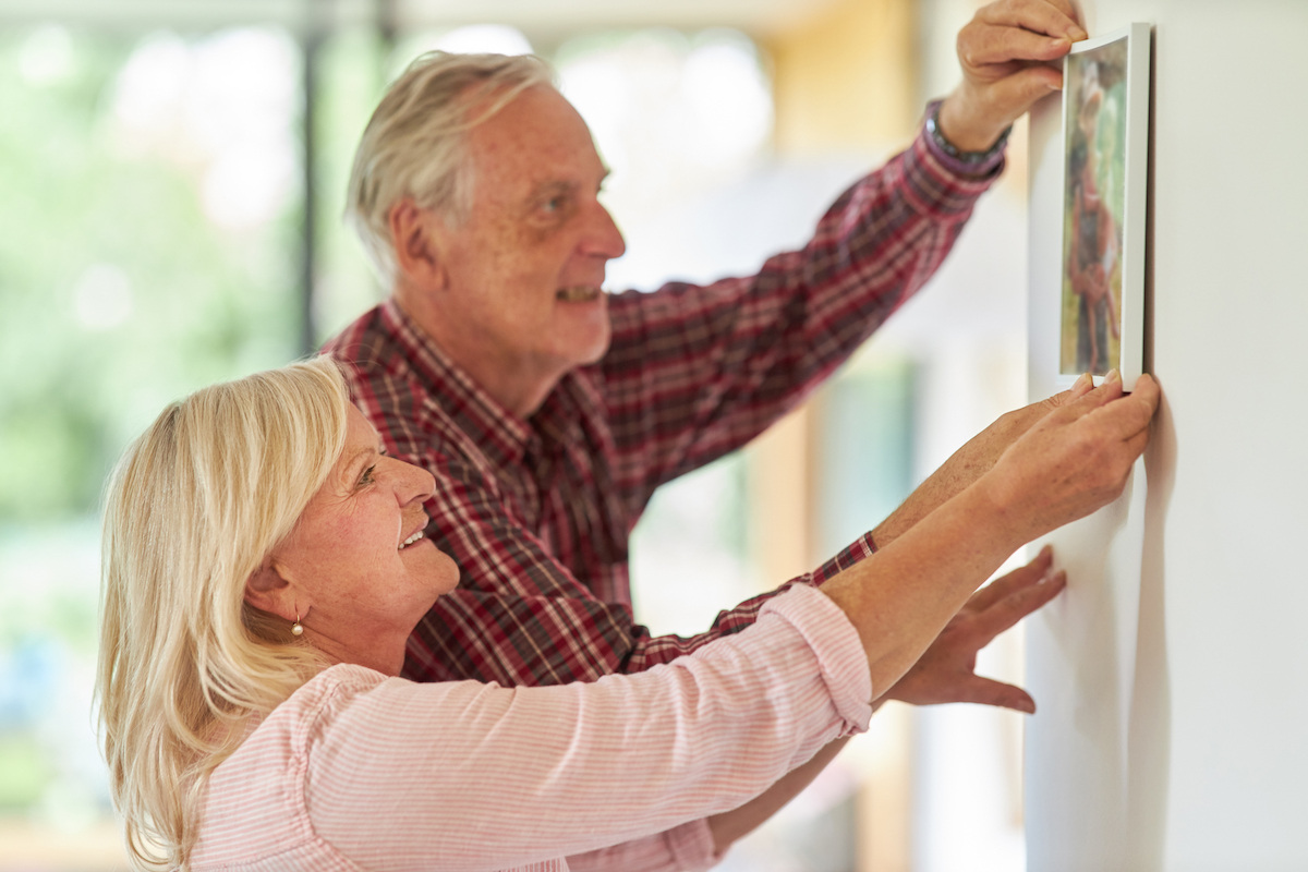 Senior,Couple,Hangs,A,Photo,Together,On,The,Wall,In