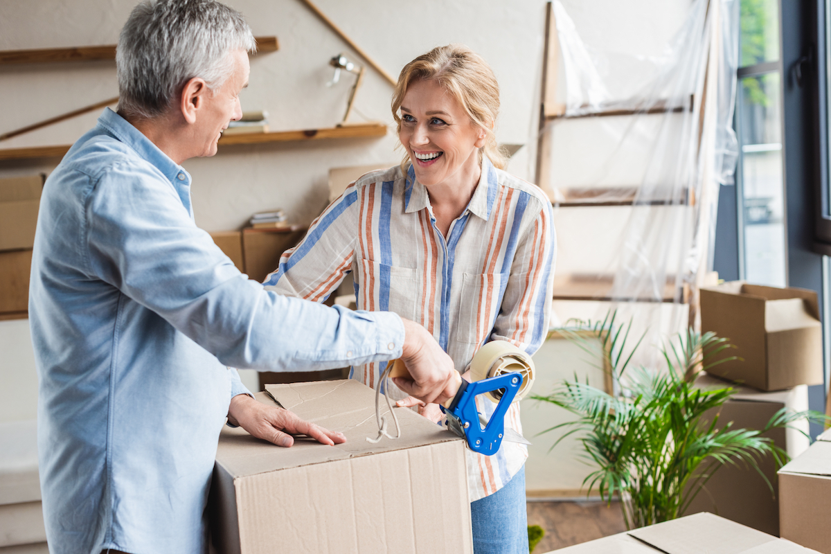 Happy,Elderly,Couple,Packing,Cardboard,Boxes,During,Relocation