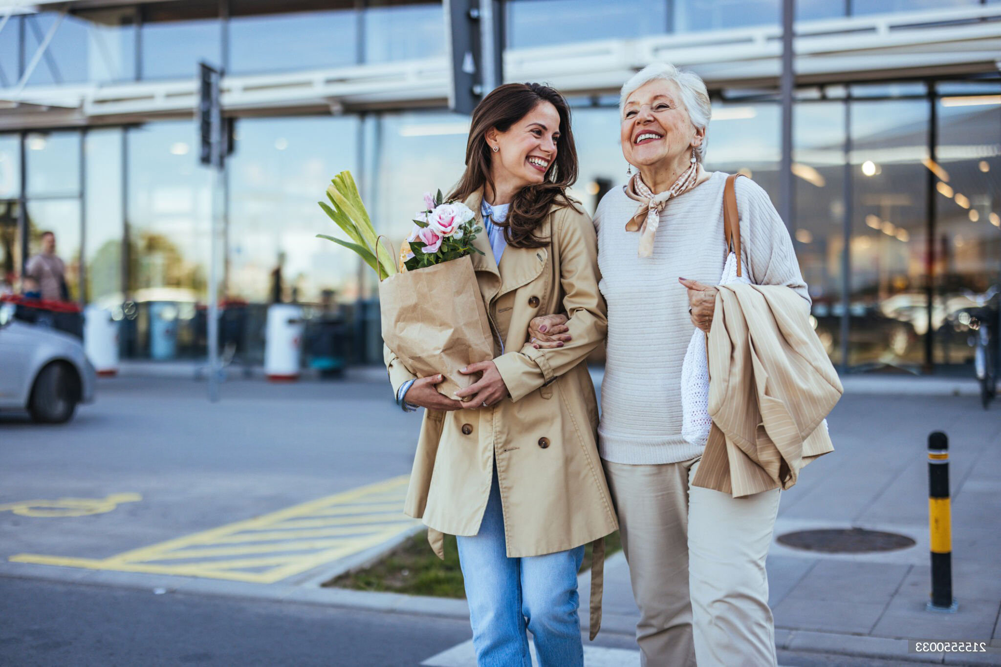 Two women walking with groceries and flowers