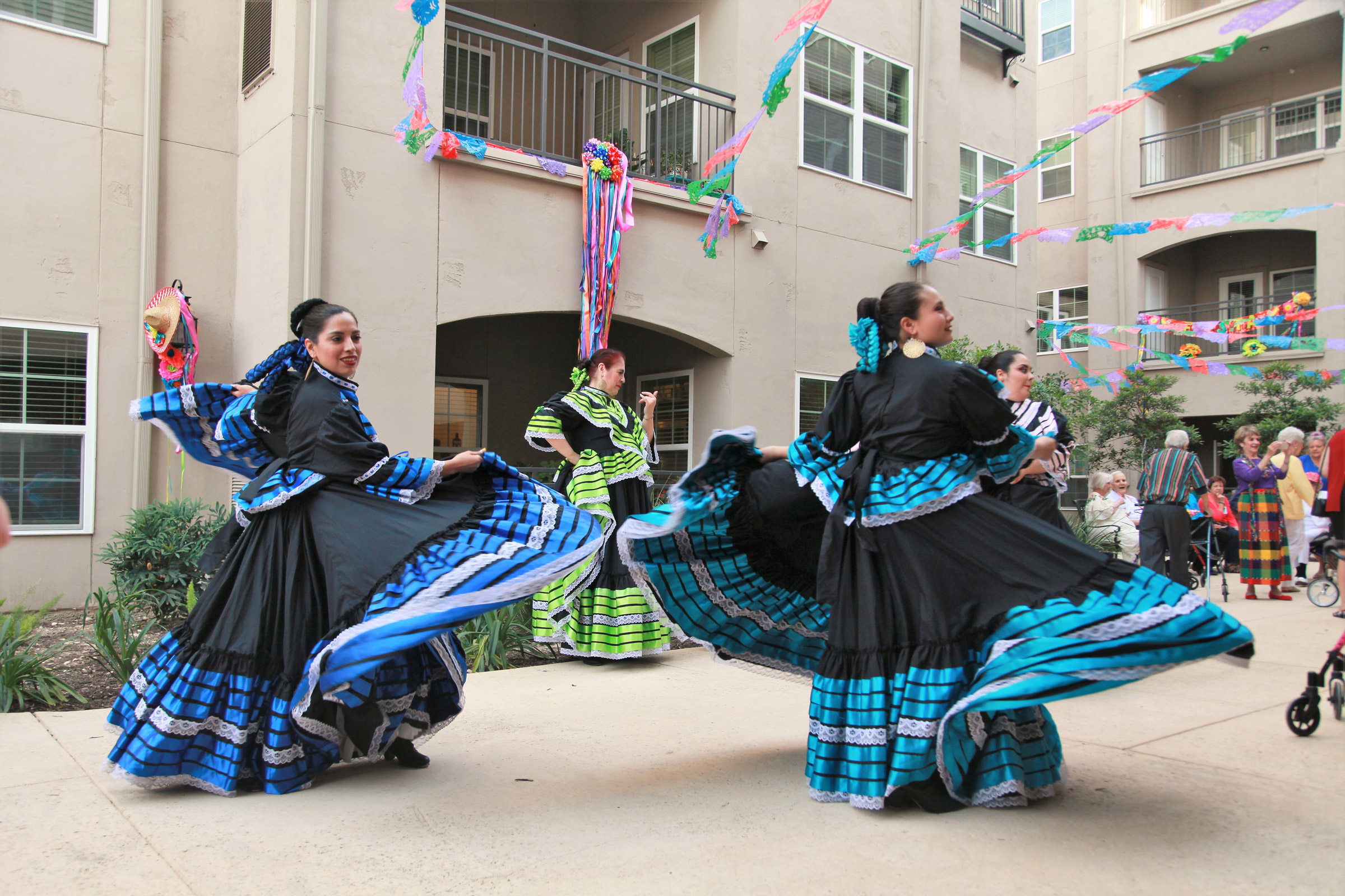 Folkloric dancers performing in colorful dresses outdoors