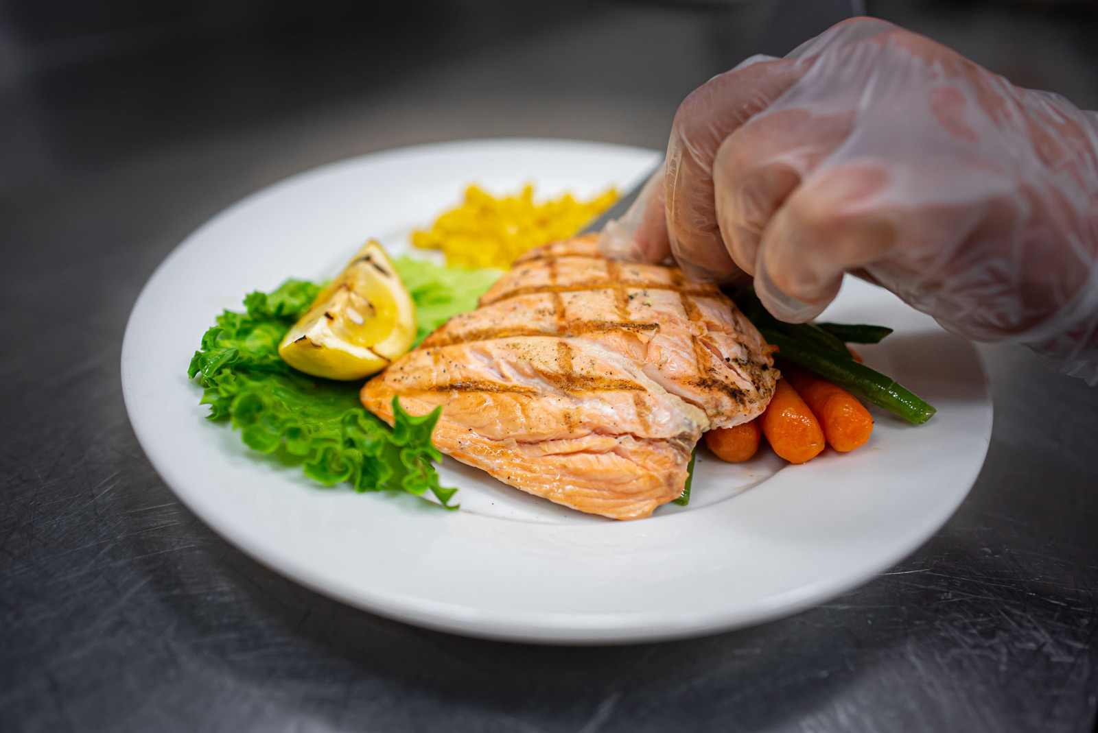 Grilled salmon with vegetables on white plate