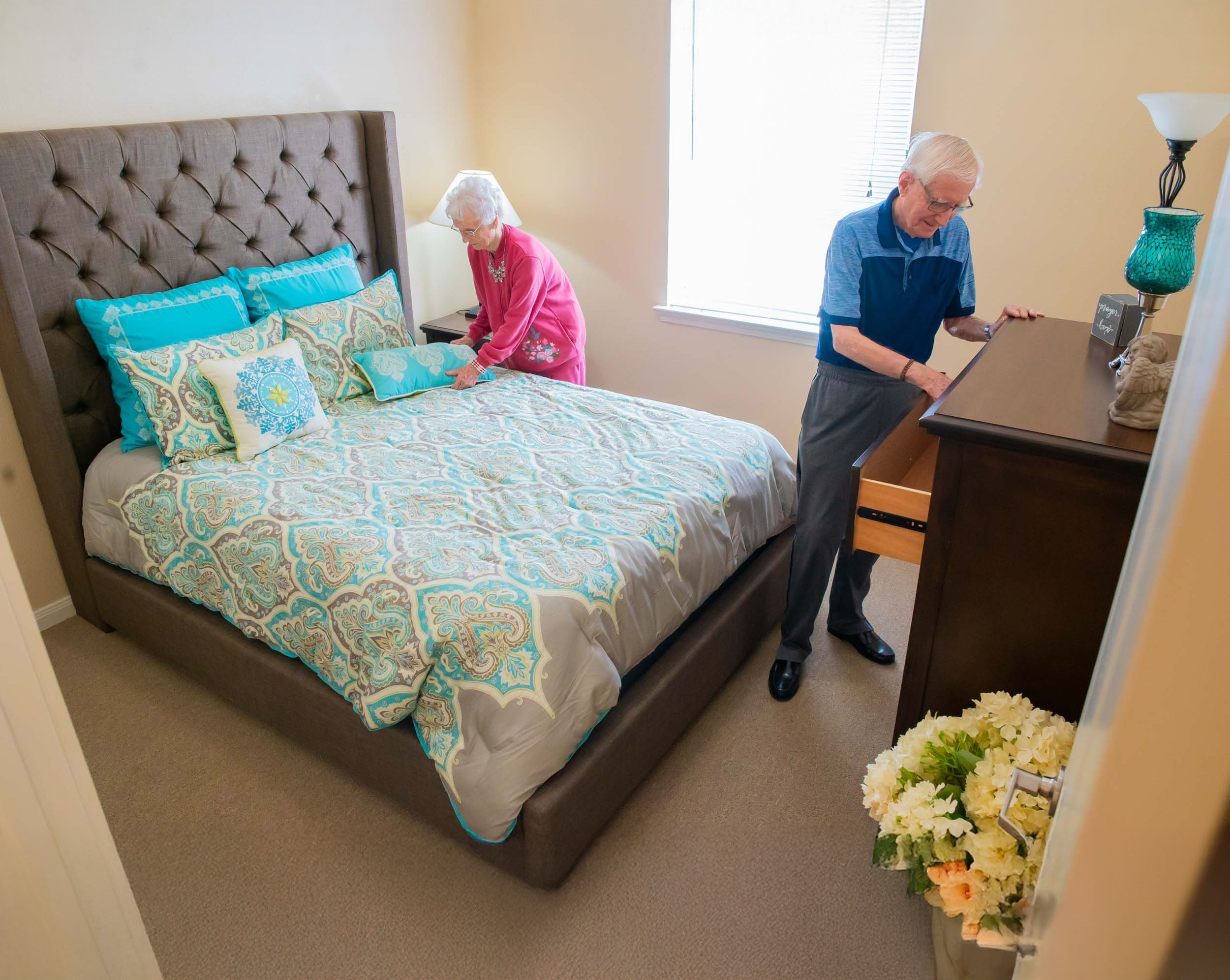 Senior couple tidying bedroom together