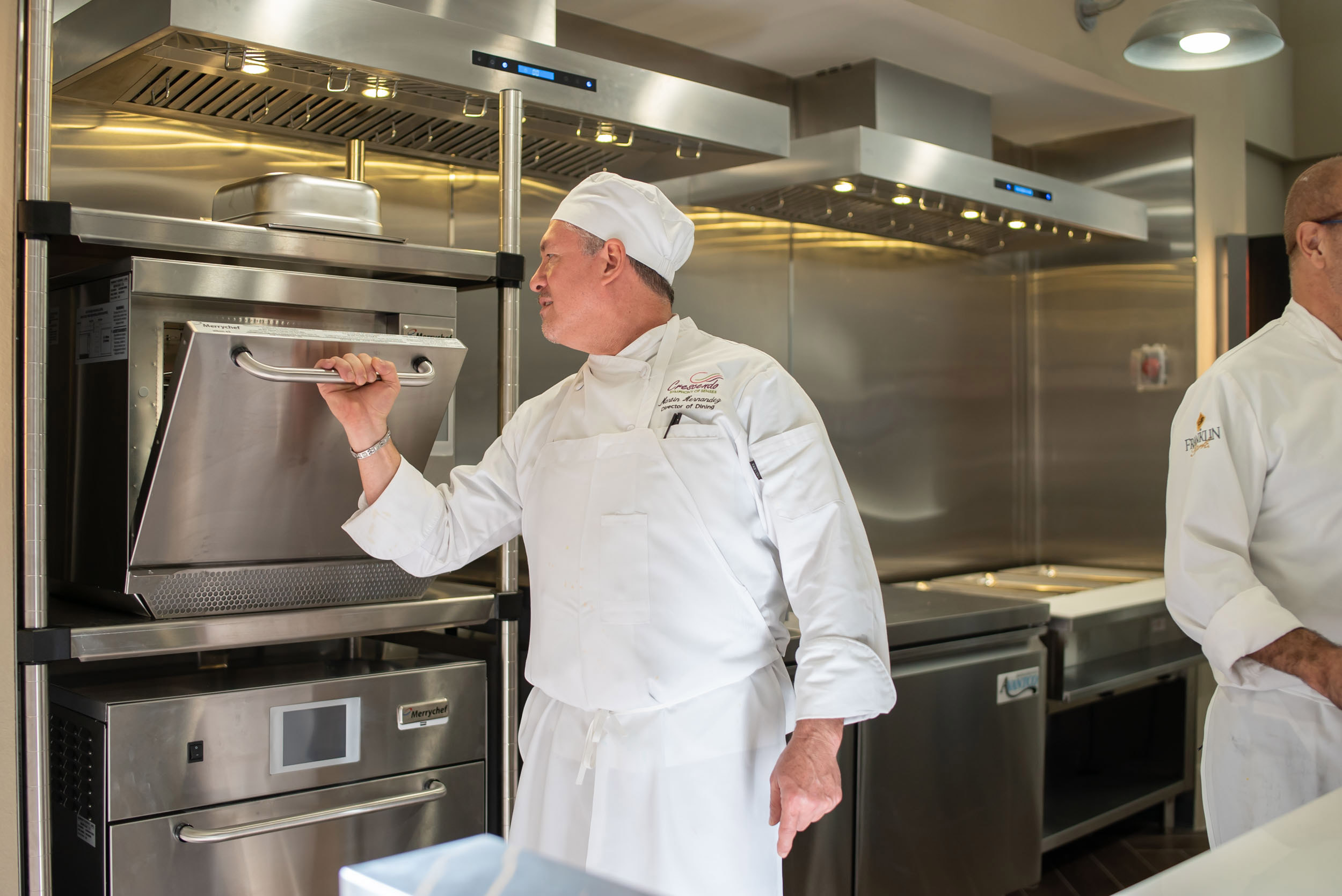 Chef opening commercial oven in professional kitchen