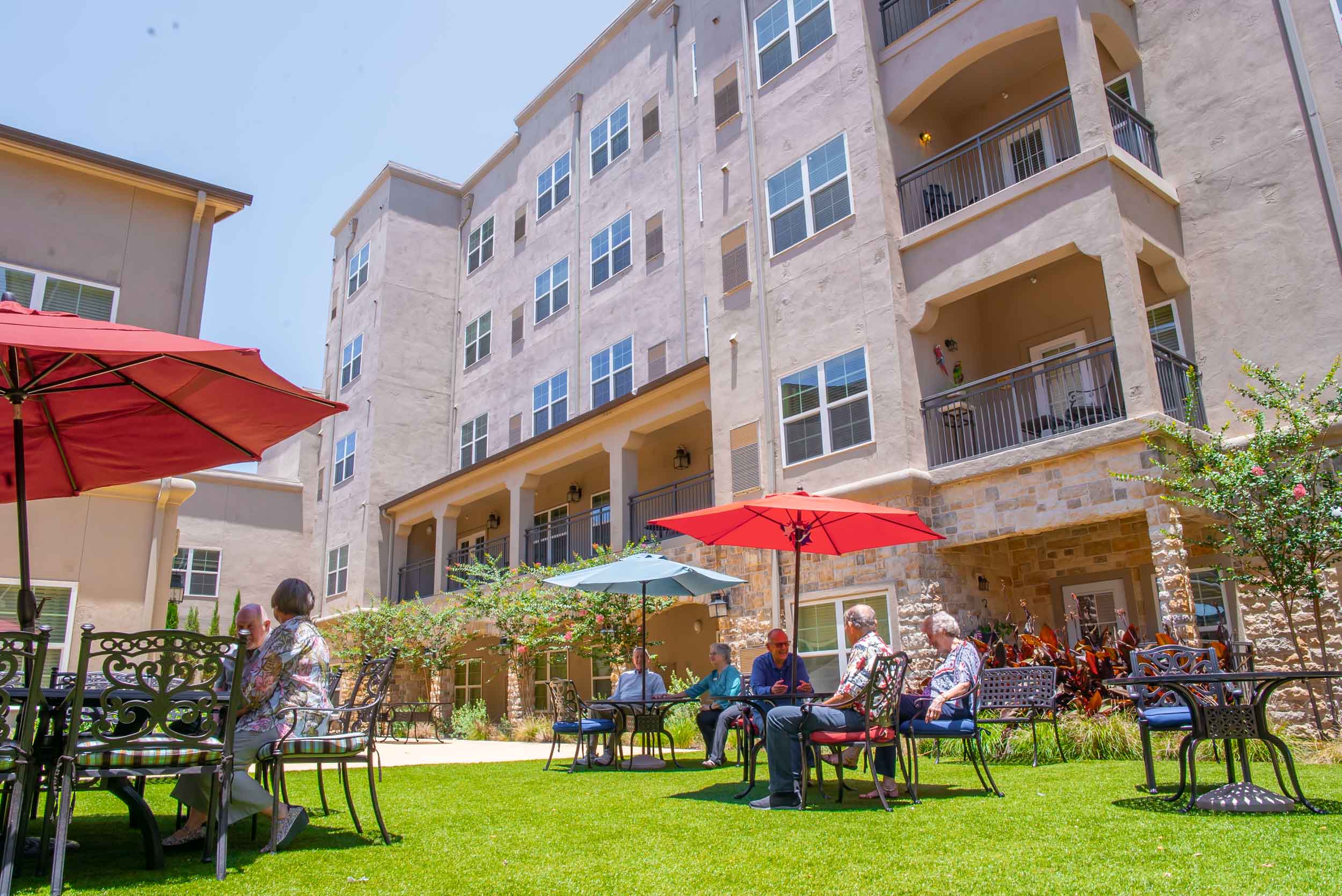 Seniors relaxing on patio outside apartment building