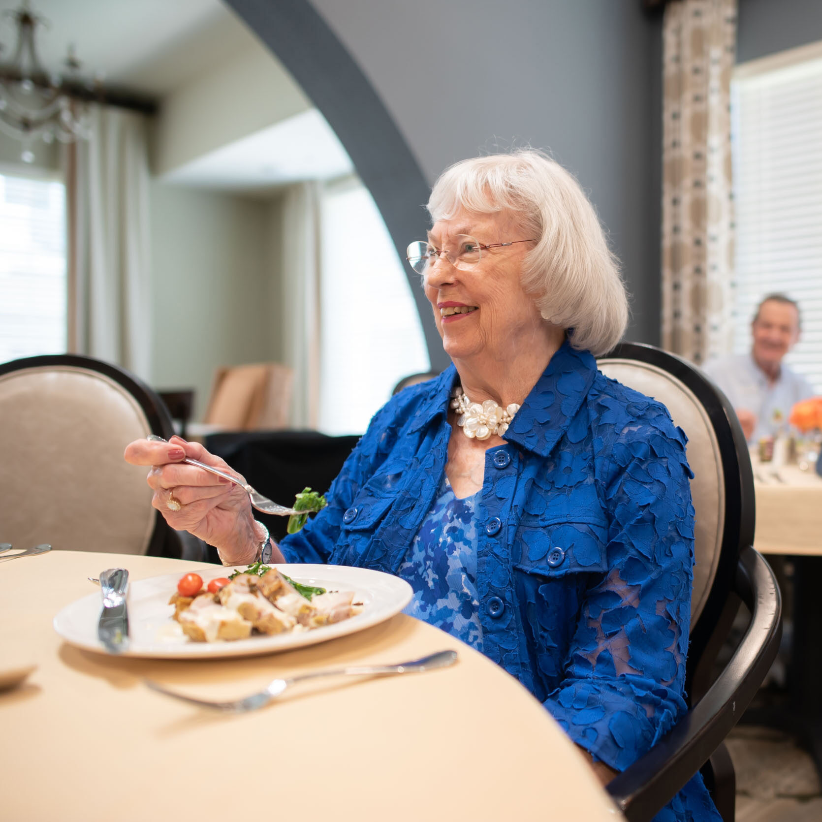Senior woman enjoying meal in dining room
