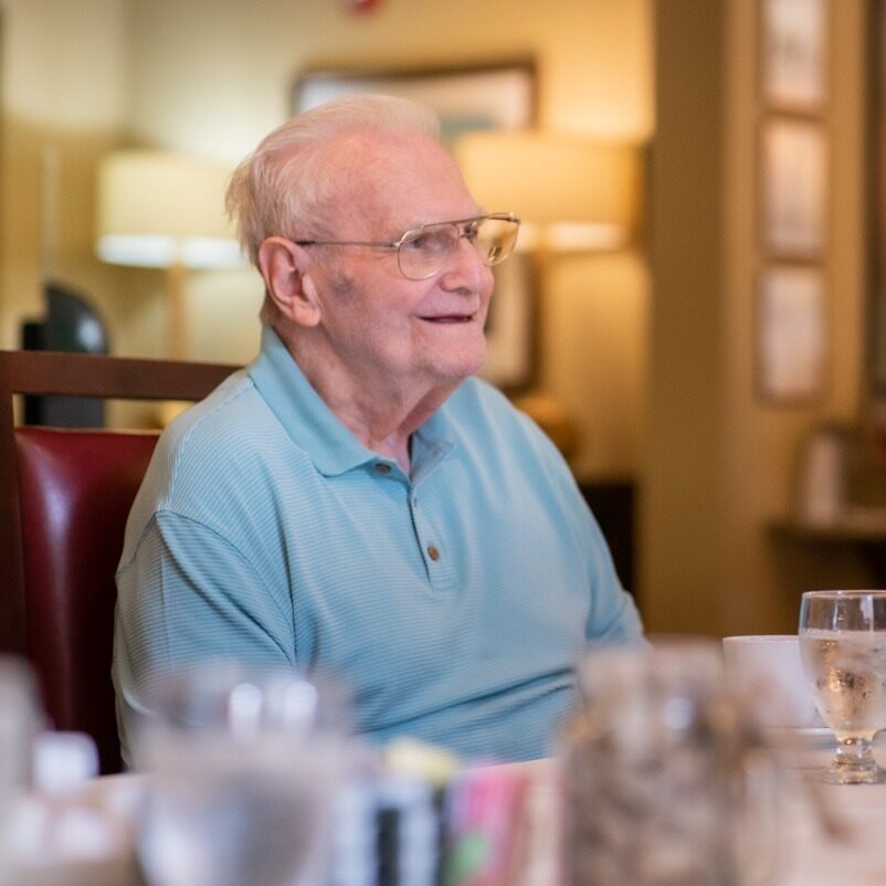 Elderly man smiling at restaurant table
