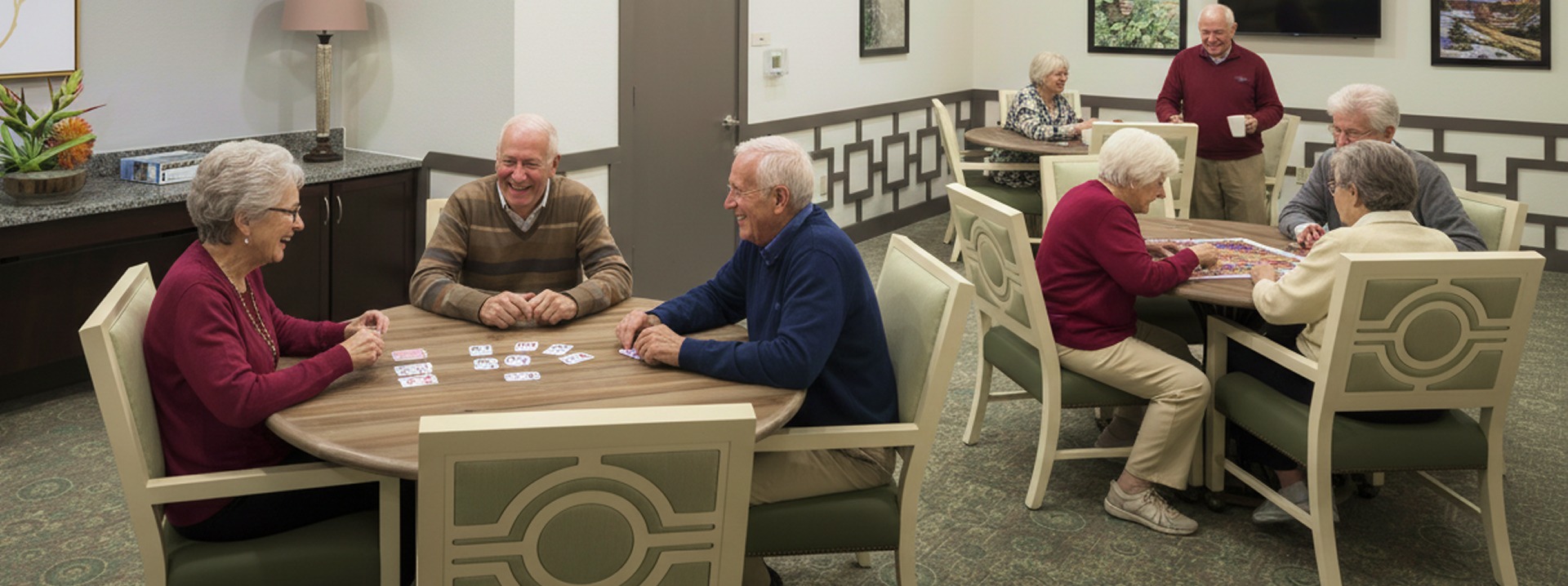 Seniors playing cards in community room