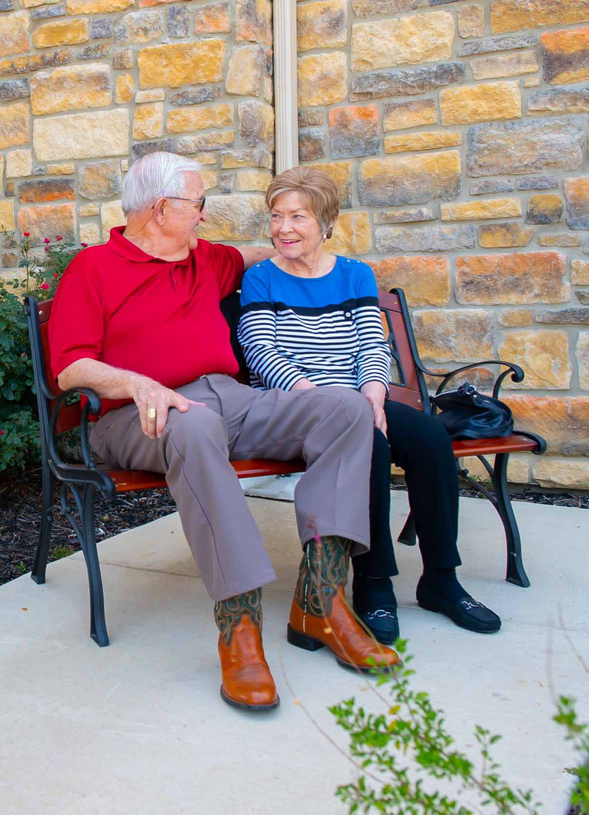 Senior couple sitting on bench outside building
