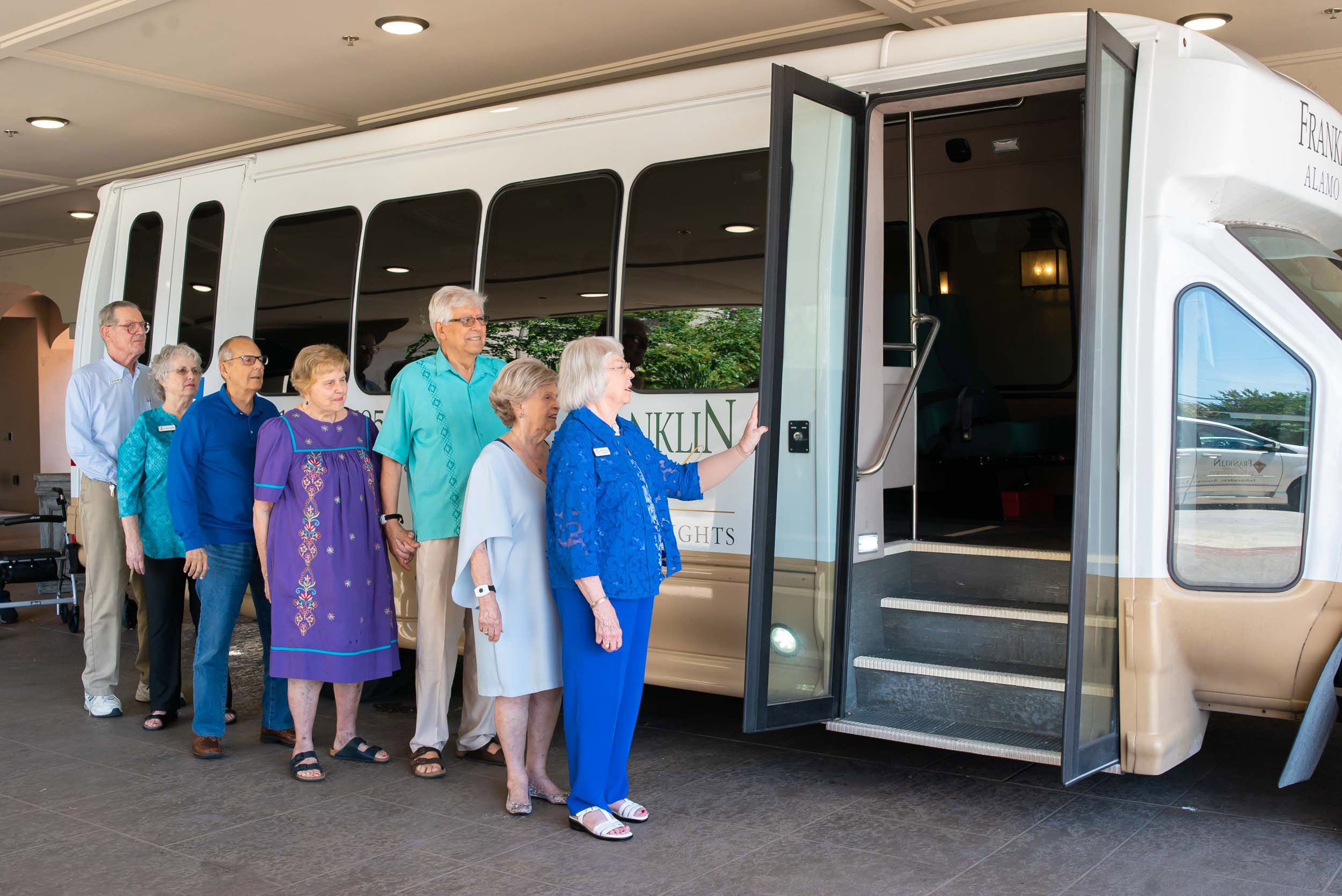 Seniors boarding community shuttle bus outside residence