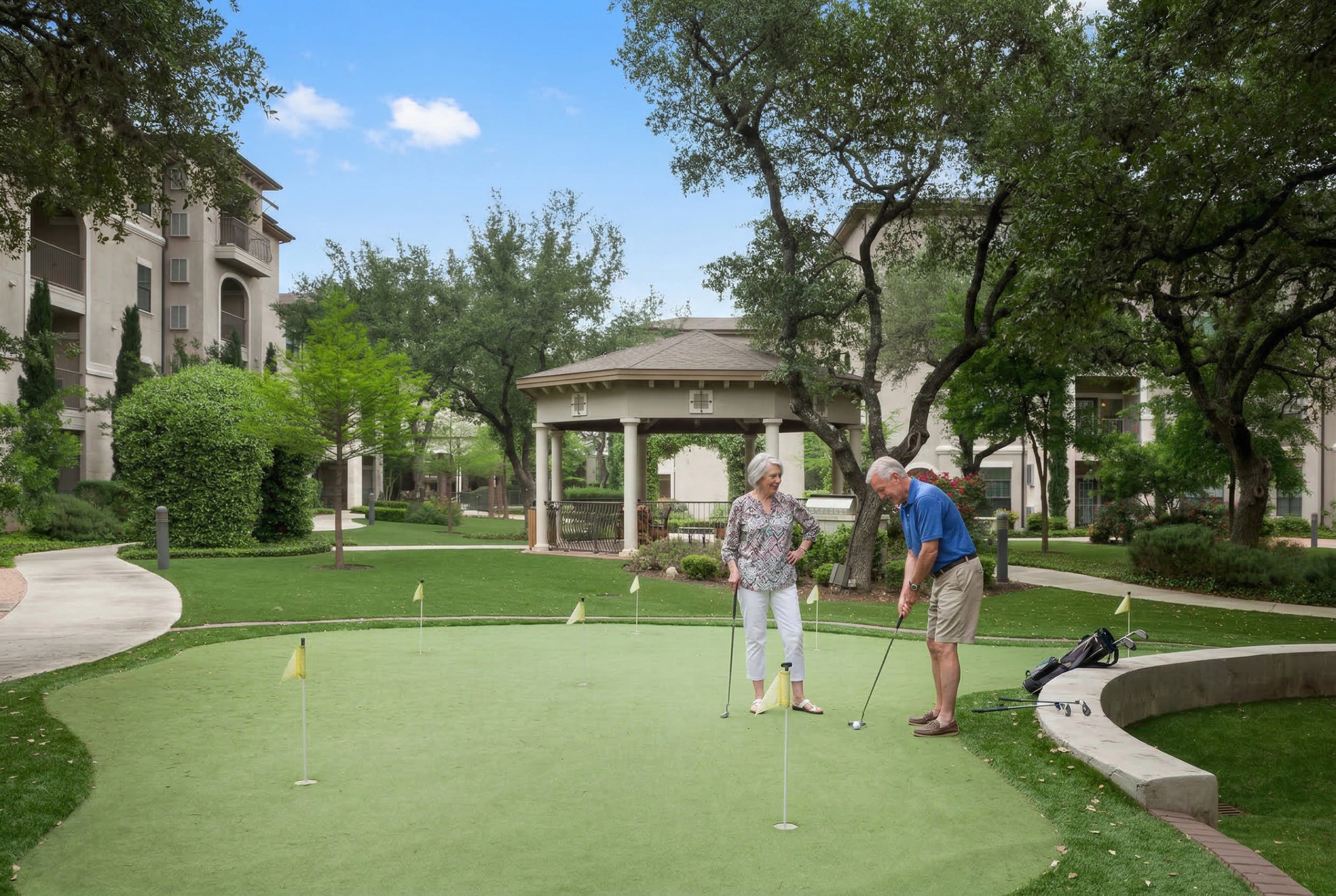 Senior couple playing golf on courtyard putting green