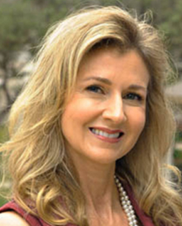 Smiling blonde woman wearing pearls outdoors