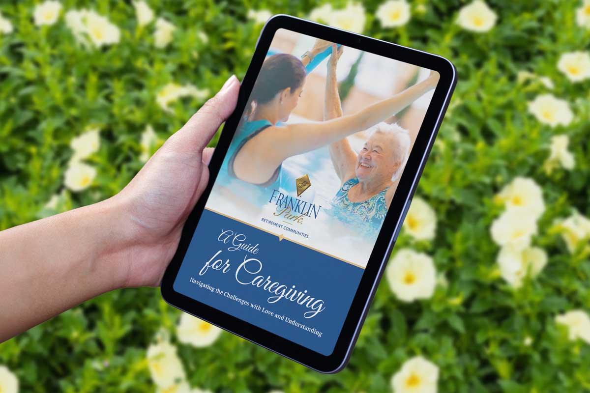 Hand holding tablet displaying caregiving guide cover