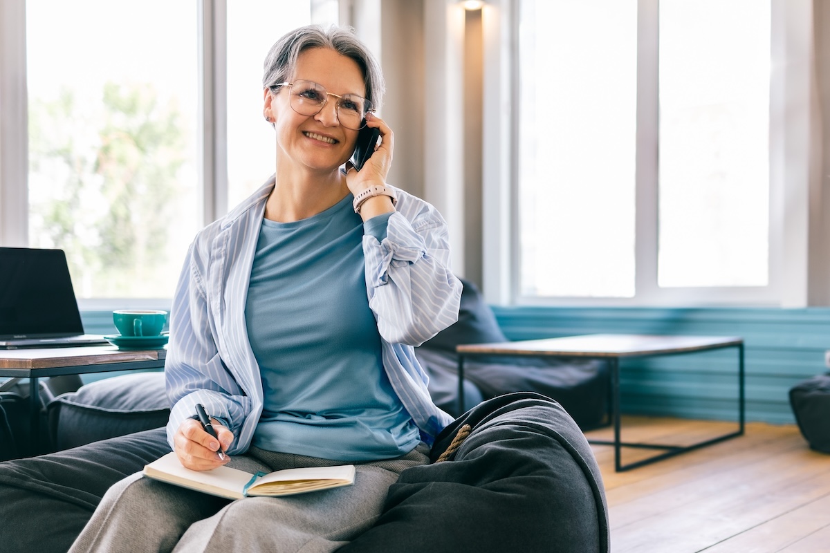 Happy,Senior,Woman,On,Phone,Call,While,Journaling,,Balanced,Lifestyle