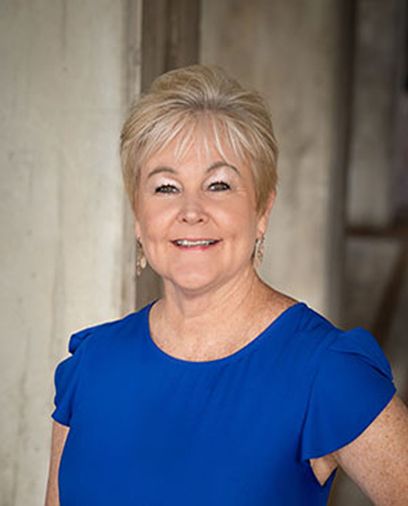 Smiling woman in blue dress indoors