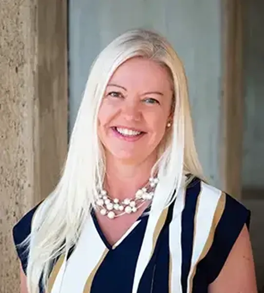 Smiling blonde woman in striped blouse and necklace